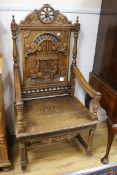A 19th century French oak Renaissance style elbow chair, the back panel carved with an interior