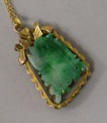 A 14ct gold mounted carved jade pendant, on an 18ct gold fine link chain, pendant 35mm.
