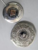 Two middle eastern white metal and niello compacts, one with filligree cover, largest 75mm.