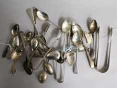 A collection of silver and white metal flatware, including sets of spoons, sugar tongs, etc.
