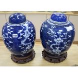 A pair of Chinese prunus pattern vases and covers with hardwood stands H.41cm