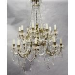 An 18th century style gilt brass and glass sixteen light chandelier, hung with lustre and tear