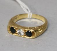 An 18ct gold and three stone sapphire and diamond ring, size O.
