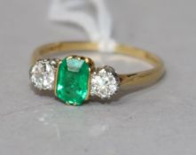 An 18ct gold, emerald and diamond three stone ring, size O.