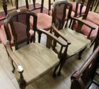 A pair of 1920's cane back elbow chairs