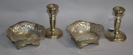 A pair of Edwardian pierced silver dishes and a pair of silver dwarf candlesticks.