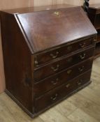 A George III mahogany bureau and an oak lamp standard W.95cm