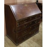 A George III mahogany bureau and an oak lamp standard W.95cm