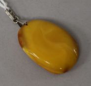 A raw amber oval pendant, gross weight 7 grams, 38mm.