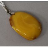 A raw amber oval pendant, gross weight 7 grams, 38mm.