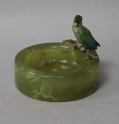 A small onyx ashtray mounted with a cold painted bronze parrot in the manner of Bergman