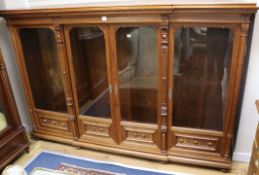 A 19th century French carved walnut four door glazed bookcase W.232cm