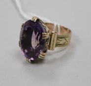 An engraved yellow metal and amethyst set dress ring, size L.