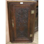 A late 18th century later carved oak corner cupboard