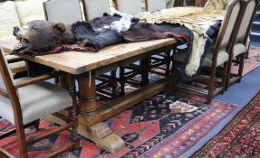 A 17th century style oak refectory table on double turned end supports W.305cm