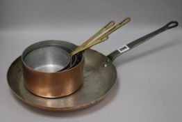 Three brass handled copper saucepans and an iron handled pan