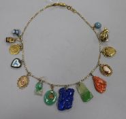 A white and yellow metal necklace (unmarked), hung with 14 various pendants and charms, including an
