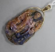 A yellow metal mounted corundum pendant carved with the figure of Guan Yin, 52mm.