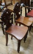 A pair of William IV carved mahogany hall chairs