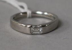 A modern platinum and solitaire emerald cut diamond ring, size O.