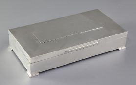 A 1960's engine turned silver rectangular cigarette box, on bracket feet, Padgett & Braham Ltd,