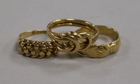 Three 18ct yellow gold rings, including a knot ring, a basket weave ring and a gimmel or fede