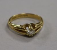 A late Victorian 18ct gold and claw set solitaire diamond ring with split shank shoulders, size P.