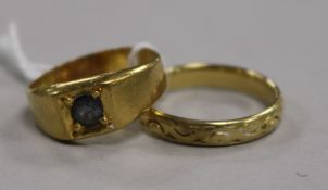An 18ct yellow gold wedding ring with carved decoration and a yellow metal ring set with a blue