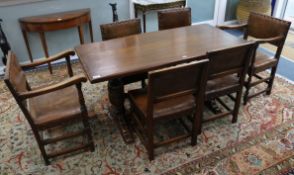 A 17th century style carved oak refectory table and six leather upholstered chairs W.152cm