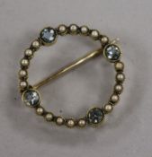 An Edwardian 15ct gold target brooch-cum-pendant set four aquamarines and seed pearls, 22mm.