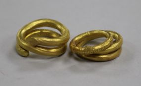Two yellow metal spiral rings, one engraved and engraved torc-style ring, all testing as 22ct