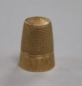 A rose-coloured yellow metal thimble with textured and engraved decoration (tests as 14ct gold), 5.
