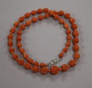 A single strand carved coral bead necklace with coral coloured spacers and diamond set clasp, 51cm.