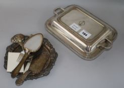 A plated entree dish with a two handled cover and sundry plated wares