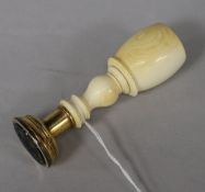 A 19th century baluster-turned ivory and gilt metal desk seal, the black onyx matrix intaglio-carved