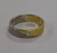 An 18ct white and yellow gold wedding band, set with a small diamond, 8.8g, size R.