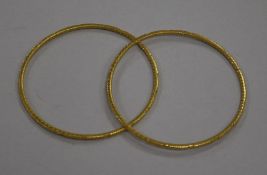 A pair of yellow metal bangles with carved decoration (test as 24ct gold), 23.3g gross