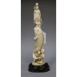 A Japanese ivory okimono of Kwannon standing upon a giant carp, early 20th century, H.24.3cms