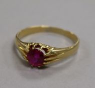 An 18ct gold and ruby ring, the circular cut stone set between channel-set shoulders, size V.