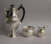 A Victorian silver three piece tea set comprising hot water pot, cream & sugar, Thomas Hayes,