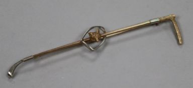An early 20th century yellow metal riding crop, spur and fox head bar brooch, 89mm.