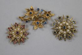 Two 9ct gold and gem set starburst brooches and a 9ct gold and gem set floral spray brooch,