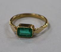 A late 1930's 18ct gold and collet set emerald ring, size K.