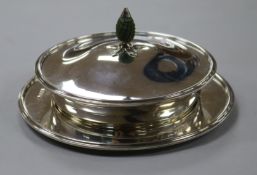 A George V silver butter dish, cover and stand, with glass liner and carved stained ivory finial,