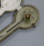 A yellow metal and gem set spider hat pin in original box, 17cm.