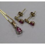 A modern 9ct gold, ruby and diamond set suite of jewellery, comprising pendant on chain and pair