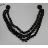A triple strand simulated dark amber graduated bead choker necklace with carved disc terminals.