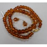 A single strand facetted amber bead necklace and a pair of matching earrings.