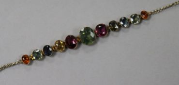 An early 20th century yellow metal and graduated multi gem set bracelet. 16.5cm.