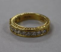 A modern 18ct gold and ten stone diamond half eternity ring, with carved shank, size N.